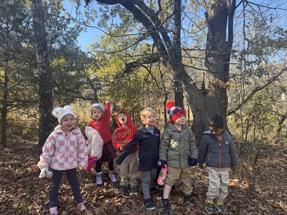 Young Selwyn students walking a wooded trail on campus in winter coats
